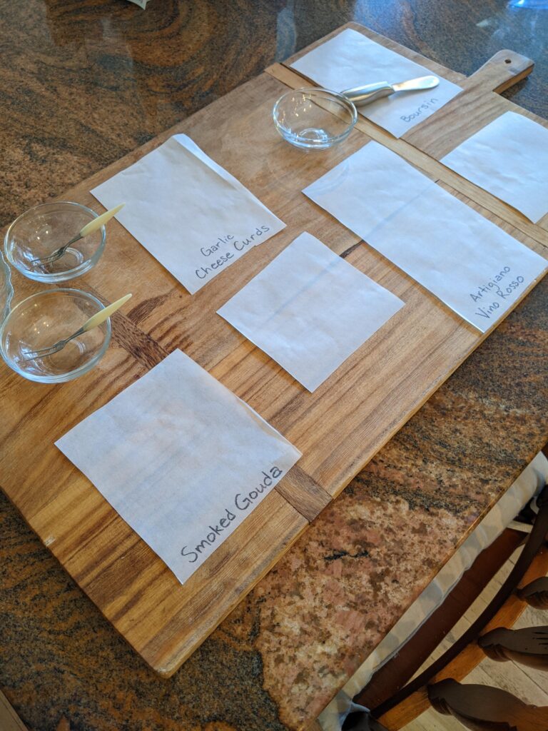 Setting up my charcuterie board with markers for the types of cheese and how I lay things out.