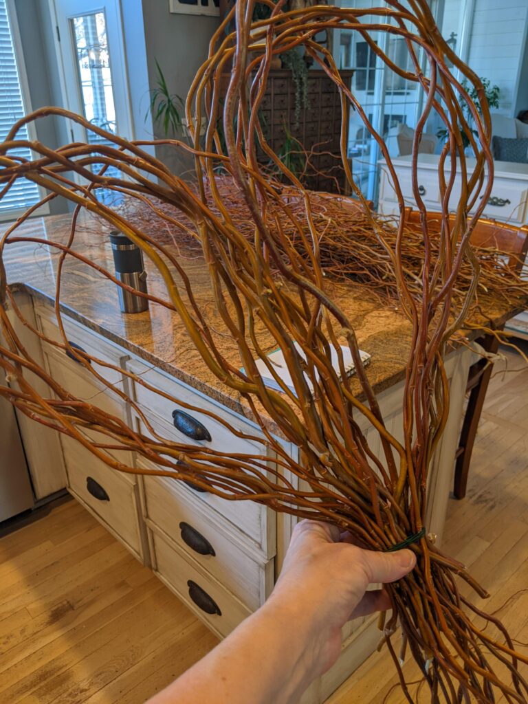 Gathering each side of the branches to form the heart shape of the curly willow wreath.